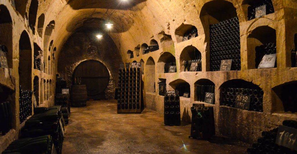 Cave voûtée avec des casiers pour les bouteilles creusés à même la pierre.